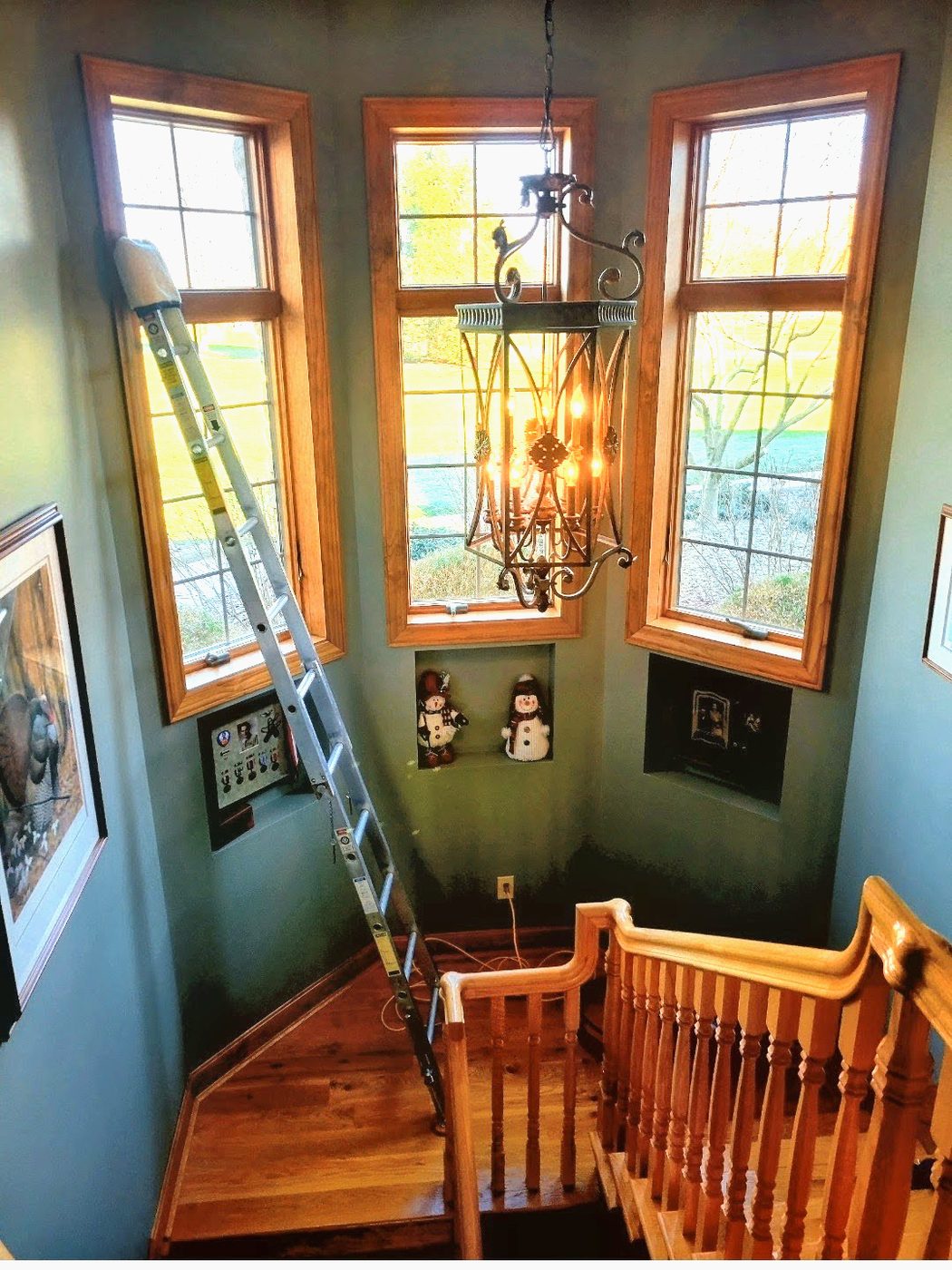 Down to Earth reaching tall stairwell windows with an extension ladder to clean hard-to-reach glass