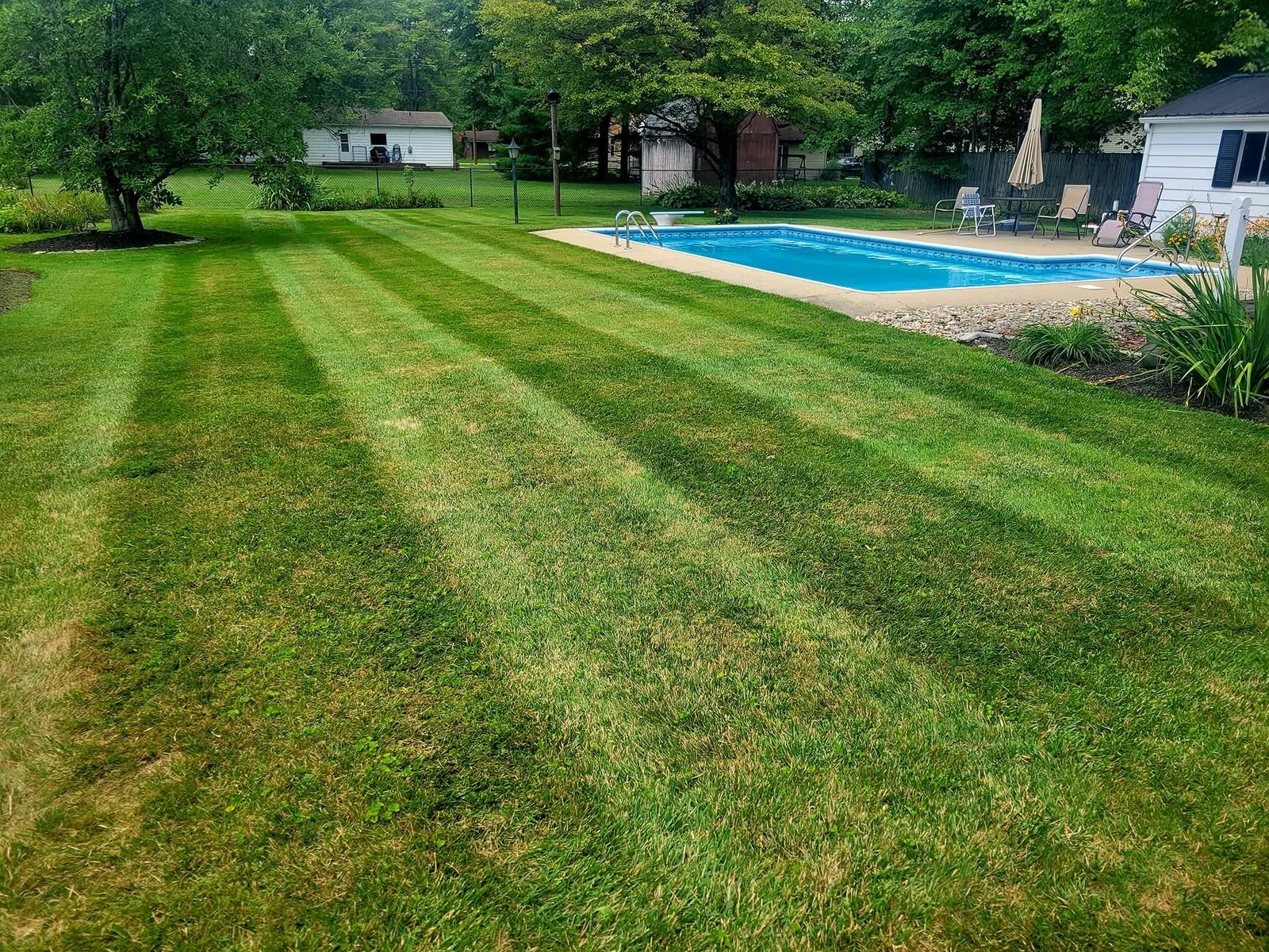 Professionally mowed striped yard with pool — lawn care service near Batavia, Ohio